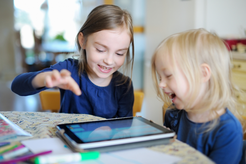Two kids learning on a tablet